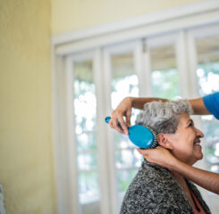 caretaker assisting elderly woman brush hair 1435014498 1200 776